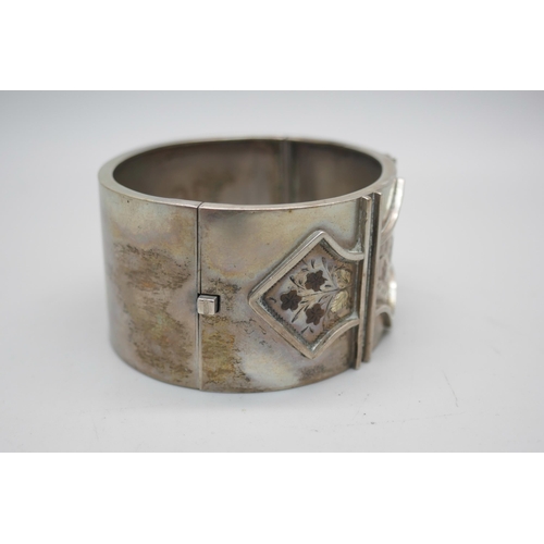 858 - A Victorian engraved silver cuff bangle with floral detail, the clasp marked Sterling Silver, 38g