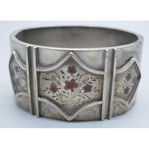 858 - A Victorian engraved silver cuff bangle with floral detail, the clasp marked Sterling Silver, 38g