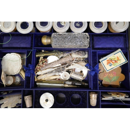 868 - A coromandel sewing box with a large collection of sewing related items, mother of pearl cotton reel... 