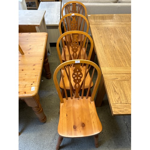 1567 - A set of four pine wheelback dining chairs