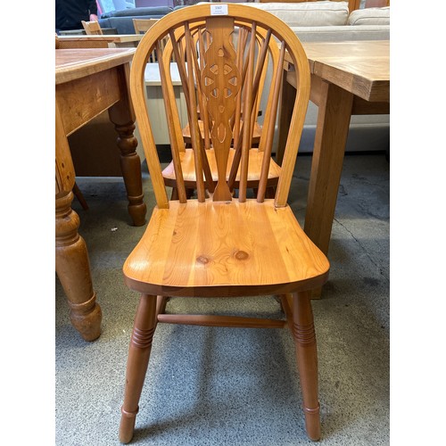 1567 - A set of four pine wheelback dining chairs