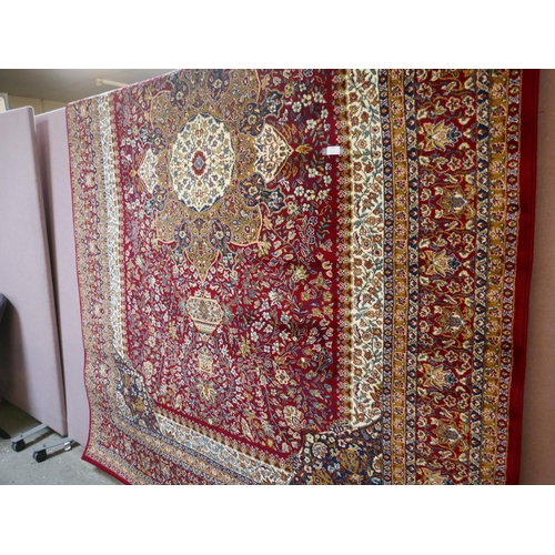 1491 - A red ground full pile Mashad carpet, floral medallion design