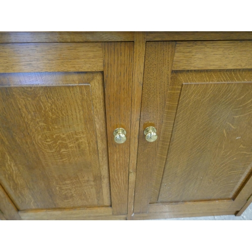 1543 - An oak leather topped two door cabinet