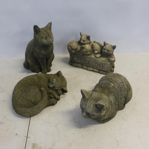 2182 - Four concrete garden cat ornaments including a 'Welcome' sign