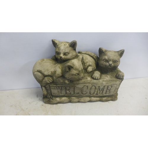 2182 - Four concrete garden cat ornaments including a 'Welcome' sign