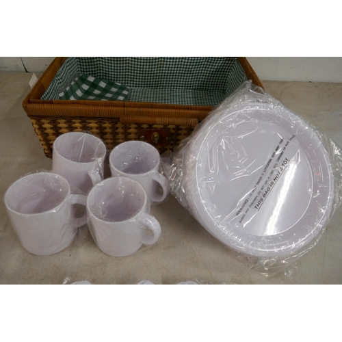 2365 - A wicker picnic hamper basket containing plastic plates, mugs and cutlery