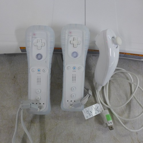 2082 - A Nintendo Wii console with A/V cables, motion detector, two Wii controllers, a nun chuck controller... 