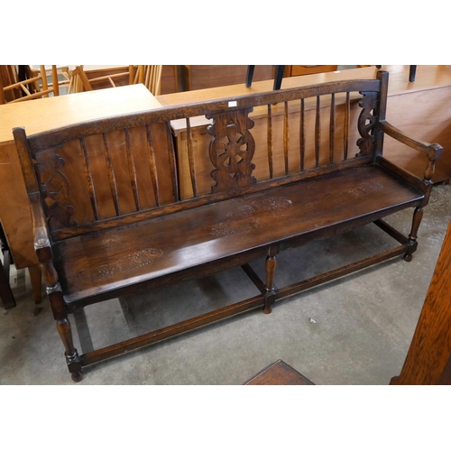 194 - A 19th Century style oak wheelback hall bench