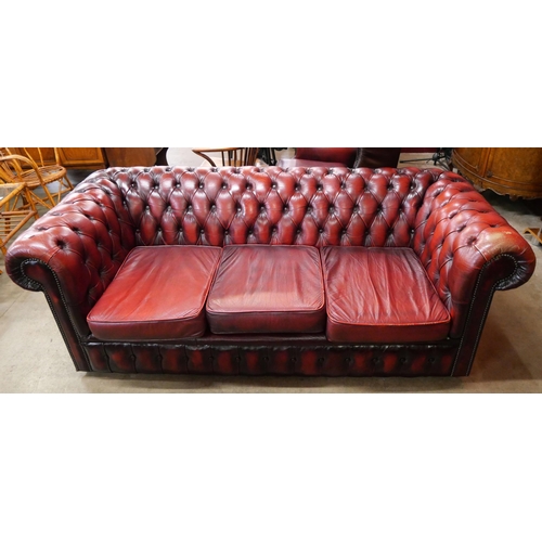 264 - An oxblood red leather Chesterfield settee