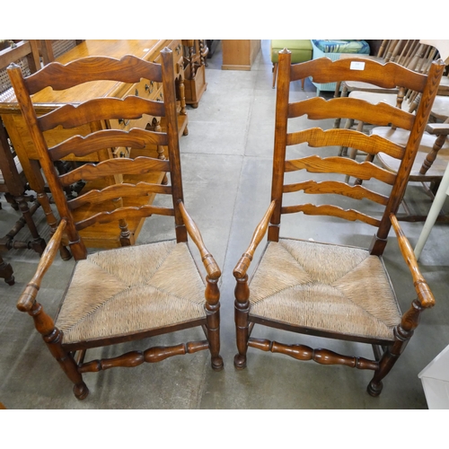 232 - A pair of George III style elm rush seated ladderback fireside chairs