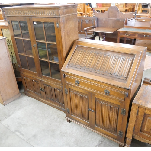 235 - A carved oak linenfold bookcase and a bureau