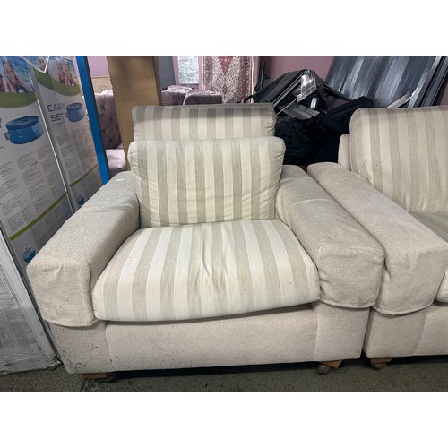 1544 - A cream fabric three piece suite comprising of a three seater sofa, two armchairs and a wingback cha... 