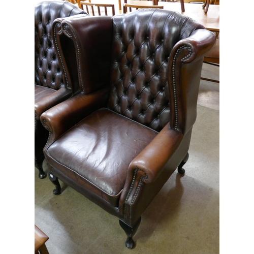 118 - A chestnut brown leather Chesterfield wingback armchair