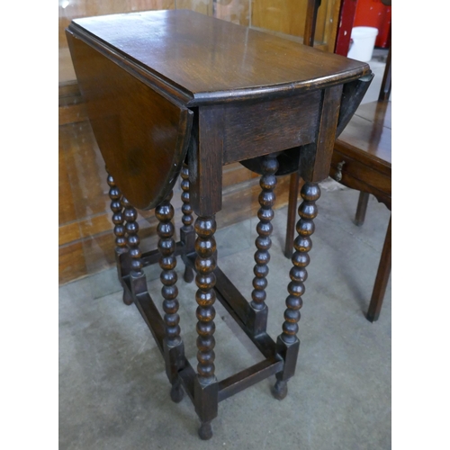 97 - A small early 20th Century oak single drawer bobbin turned gateleg table