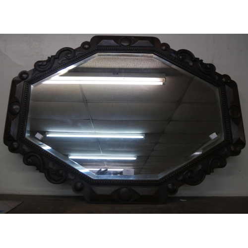 411 - An early 20th Century carved oak octagonal framed mirror