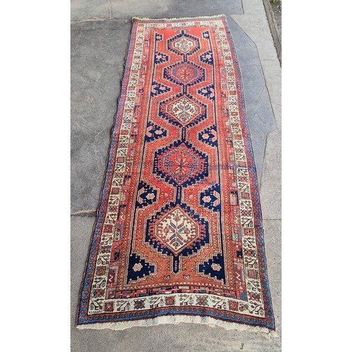 216D - An eastern terracotta ground runner rug, 300 x 115cms