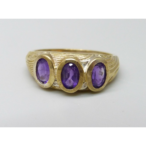 1027 - A silver gilt and amethyst trilogy ring, P