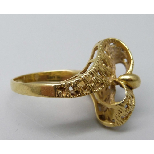 1041 - A yellow metal ring, (tests as 18ct gold, hallmark worn), with stylised cross over ribbon of gold wi... 