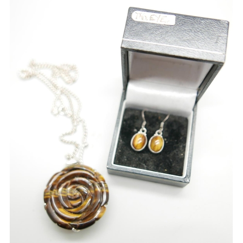 1068 - A carved silver mounted tigers eye pendant on a silver chain and a pair of tigers eye earrings, chai... 