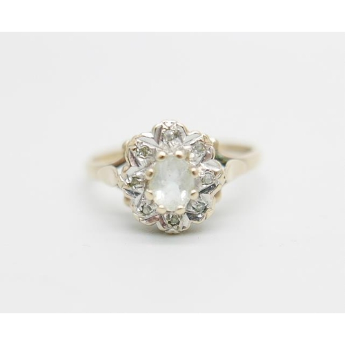 1099 - A 9ct gold ring set with a clear central stone and diamond chip halo, 2.2g, O