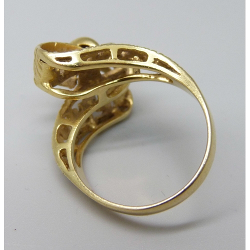 1041 - A yellow metal ring, (tests as 18ct gold, hallmark worn), with stylised cross over ribbon of gold wi... 