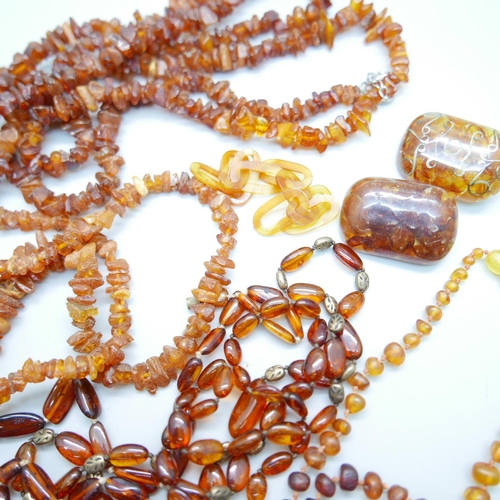 1125 - A collection of amber jewellery, two amber brooches, a child's teething amber necklace, etc