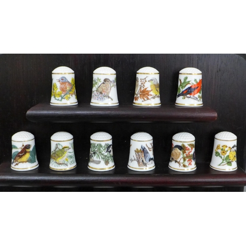 641 - A Franklin Mint set of thimbles, Songbirds of the World, 22 thimbles on a wooden stand