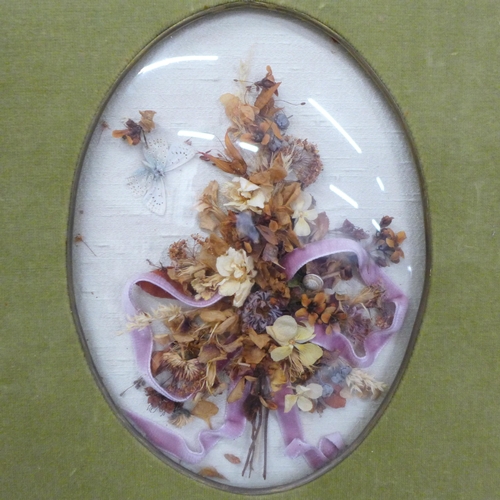 666 - An Edwardian dried flower display under a convex glass with silk photograph frame and a double leath... 