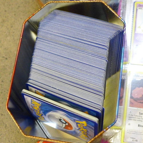 722 - A large collection of Pokemon cards including six tins containing cards, a box of cards, other acces... 