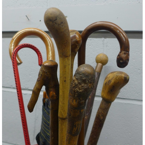 767 - A West German vase/stick stand with a collection of walking sticks and umbrellas