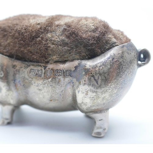 853 - A collection of silver, etc.; including silver pig pin cushion, Birmingham 1905, silver cigar rest, ... 