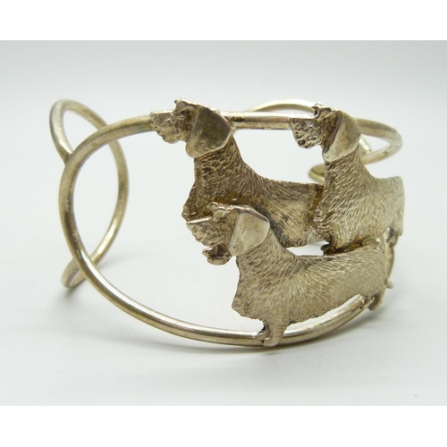 865 - A silver cuff bangle with three wired hair dachshund detail