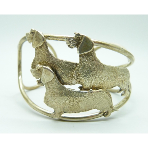 865 - A silver cuff bangle with three wired hair dachshund detail