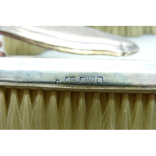 876 - Four silver backed brushes