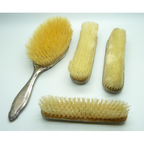 876 - Four silver backed brushes