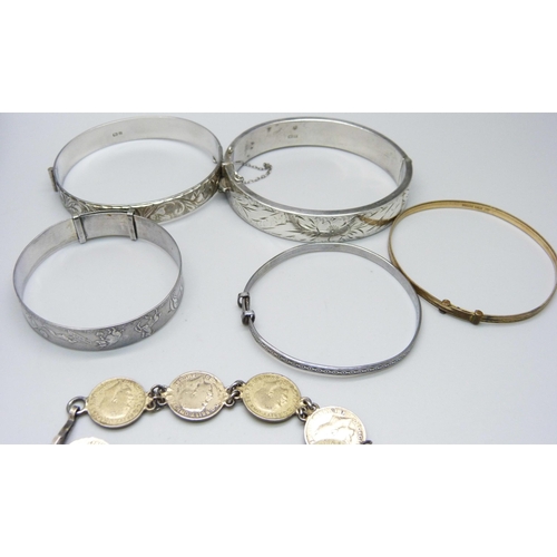 946 - Silver jewellery including four silver bangles and a silver charm bracelet, coins and a sovereign ho... 