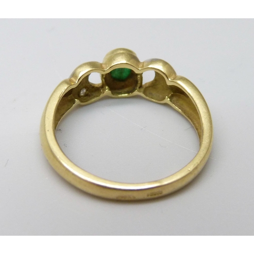 988 - An 18ct gold diamond and emerald ring, 3.5g, O