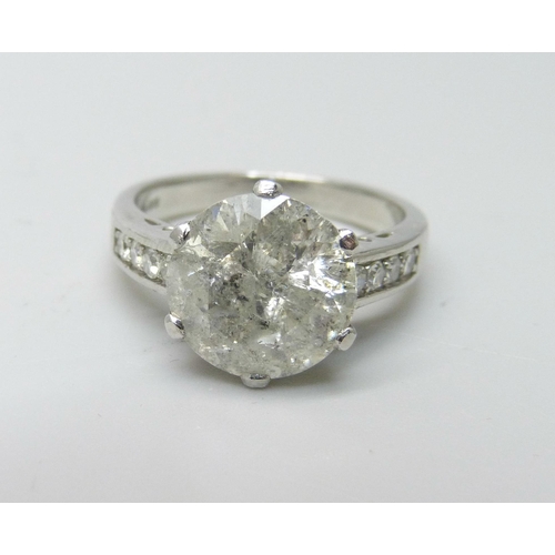 999 - A hallmarked platinum solitaire diamond ring with diamond set shoulders, 3.80cts, 6.2g, M