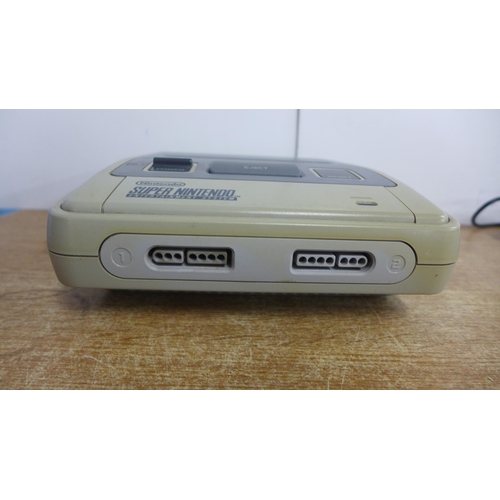 2120 - A Nintendo Super Nintendo Entertainment System console with 2 games; Super Mario World and Theme Par... 