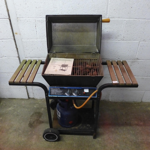 An OMC Broil King gas barbecue with instruction booklet and a 4.5kg Eurogas gas canister