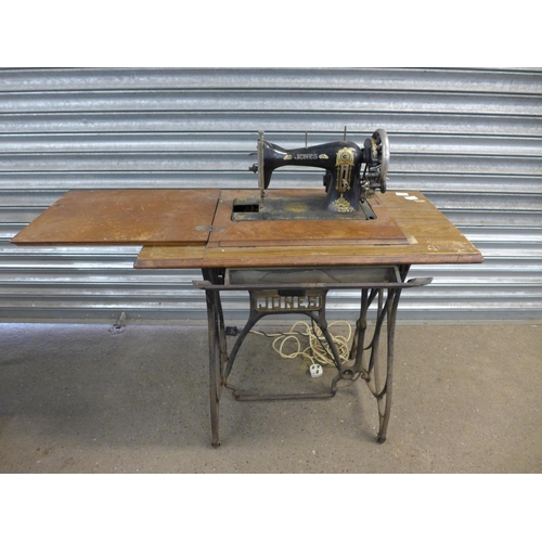 2161 - A vintage Jones treadle sewing machine with sewing machine table