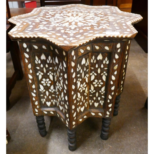 110 - A Moorish carved wood and mother of pearl inlaid star shaped occasional table