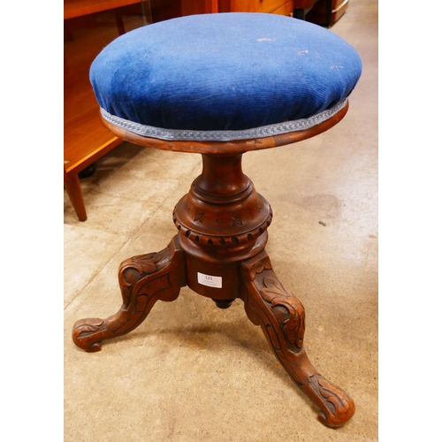 121 - A Victorian carved walnut revolving piano stool