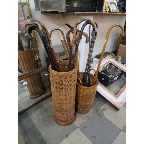 383 - Two wicker stick stands a walking sticks