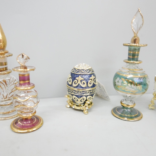 622 - Five glass perfume bottles, three enamelled and decorated brass eggs with hinged lids and one other ... 