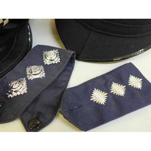 699 - A collection of Police memorabilia; helmets, caps, lapel badges, shoulder flashes, etc.