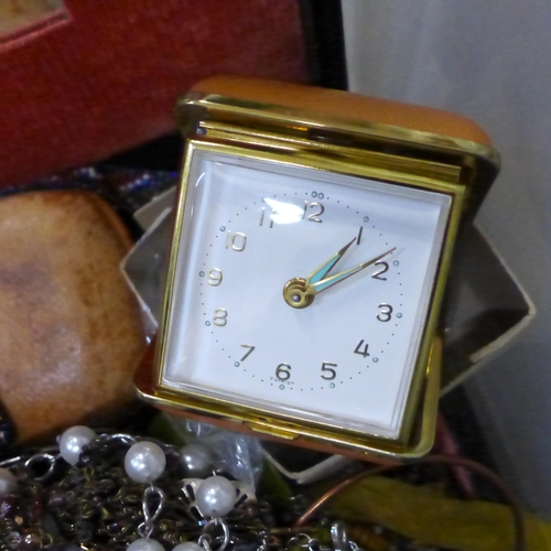 723 - A jewellery box and costume jewellery, and two cased travel clocks