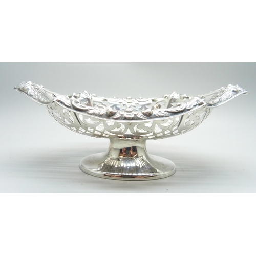 802 - A boat shaped embossed and pierced silver pedestal dish, crested, London 1898, 86g, 16.5cm