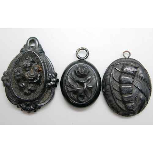 961 - Two jet pendants, one other pendant and a carved jet bead necklace, (some beads a/f)