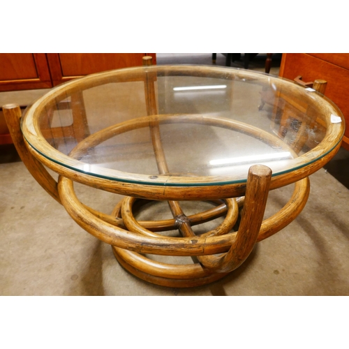 67 - A circular bamboo and glass topped coffee table
